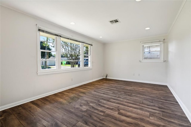 spare room featuring ornamental molding, a healthy amount of sunlight, and dark hardwood / wood-style flooring