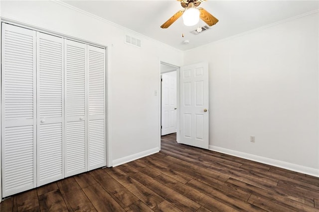 unfurnished bedroom featuring ornamental molding, dark hardwood / wood-style floors, a closet, and ceiling fan