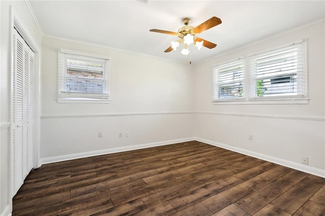 unfurnished bedroom featuring dark wood-type flooring, ceiling fan, crown molding, and multiple windows