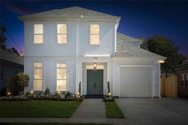 front of property with a lawn and a garage