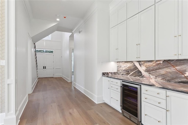 bar featuring light hardwood / wood-style floors, white cabinetry, backsplash, and wine cooler