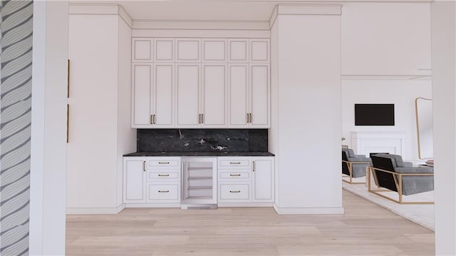 bar featuring light hardwood / wood-style floors and tasteful backsplash