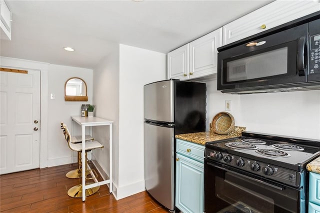 kitchen featuring white cabinets, black appliances, light stone counters, and dark hardwood / wood-style flooring