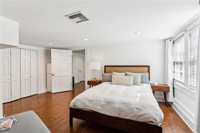 bedroom with dark wood-type flooring and a closet