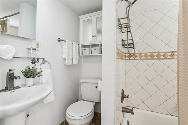 full bathroom with toilet, sink, and tiled shower / bath