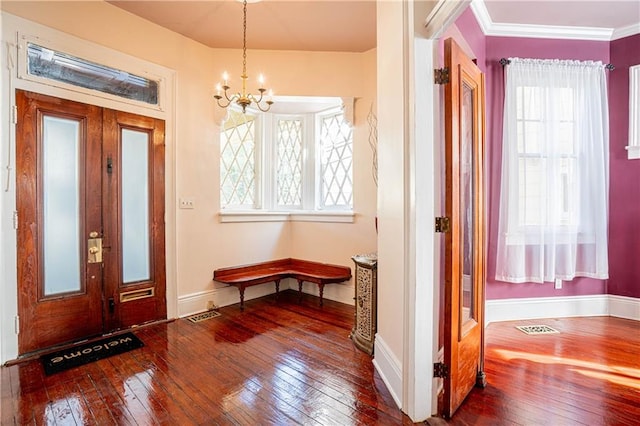 entrance foyer featuring an inviting chandelier, hardwood / wood-style floors, and crown molding