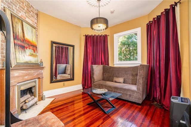 sitting room with hardwood / wood-style floors, a large fireplace, and heating unit