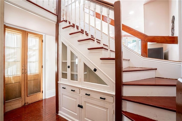 stairs featuring french doors, wood-type flooring, and a wealth of natural light