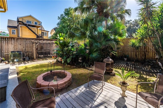 deck with a yard and an outdoor fire pit