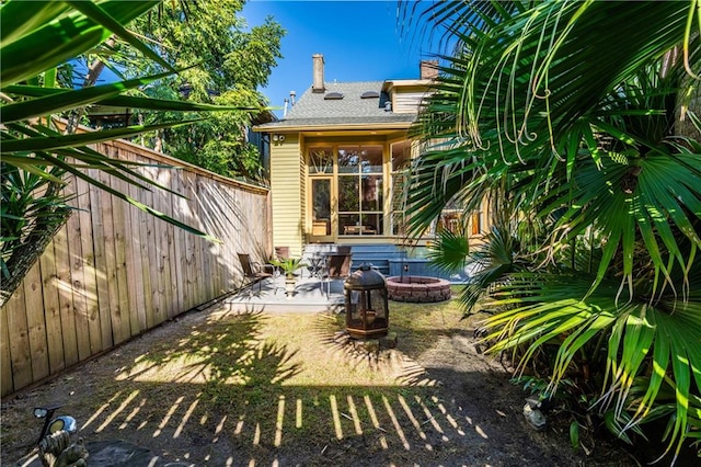 back of property with a patio and a fire pit