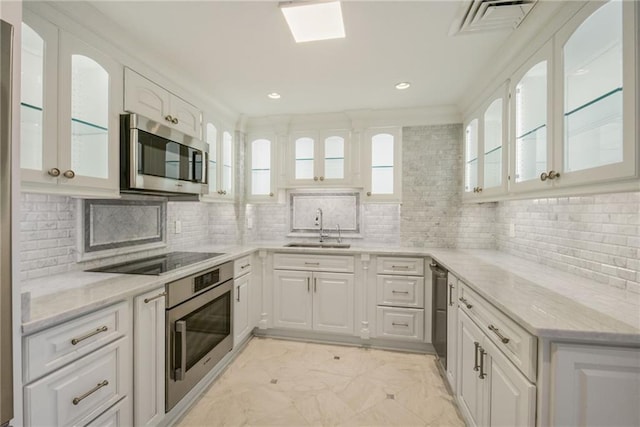 kitchen featuring white cabinets, tasteful backsplash, light stone countertops, sink, and stainless steel appliances