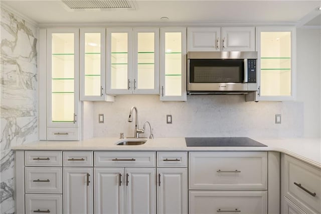 kitchen with black electric cooktop, white cabinetry, a healthy amount of sunlight, and sink