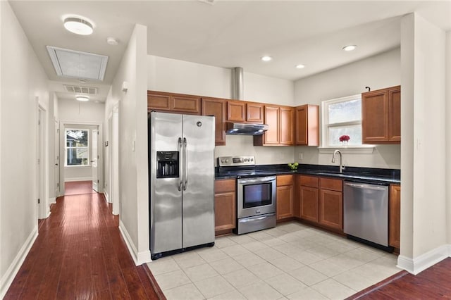kitchen with dark countertops, stainless steel appliances, visible vents, baseboards, and under cabinet range hood