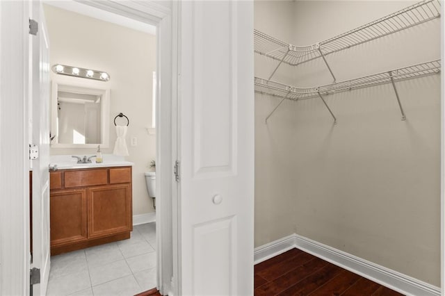 walk in closet with light wood-style flooring and a sink