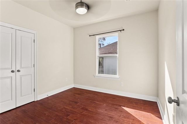 unfurnished bedroom with a closet, wood finished floors, baseboards, and ceiling fan