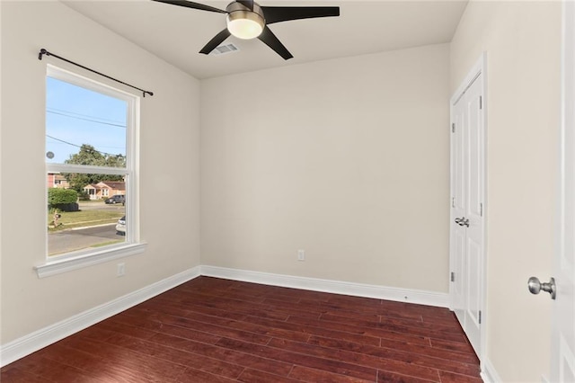 empty room featuring ceiling fan, visible vents, baseboards, and hardwood / wood-style floors
