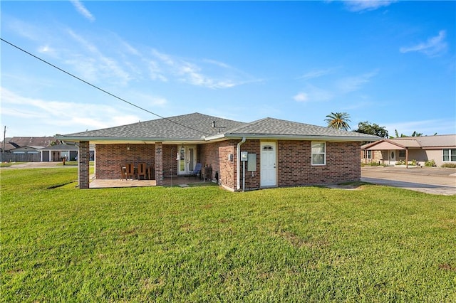 rear view of property featuring a patio and a lawn