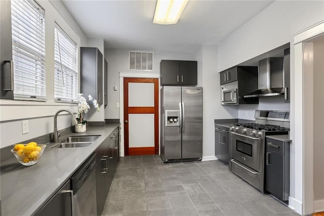 kitchen featuring wall chimney range hood, appliances with stainless steel finishes, and sink