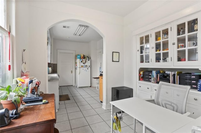 kitchen featuring white cabinetry, white fridge, and light tile patterned flooring