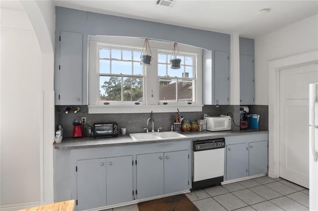 kitchen with sink, decorative backsplash, white appliances, and light tile patterned floors