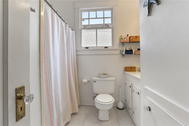 bathroom with toilet, walk in shower, vanity, and tile patterned floors