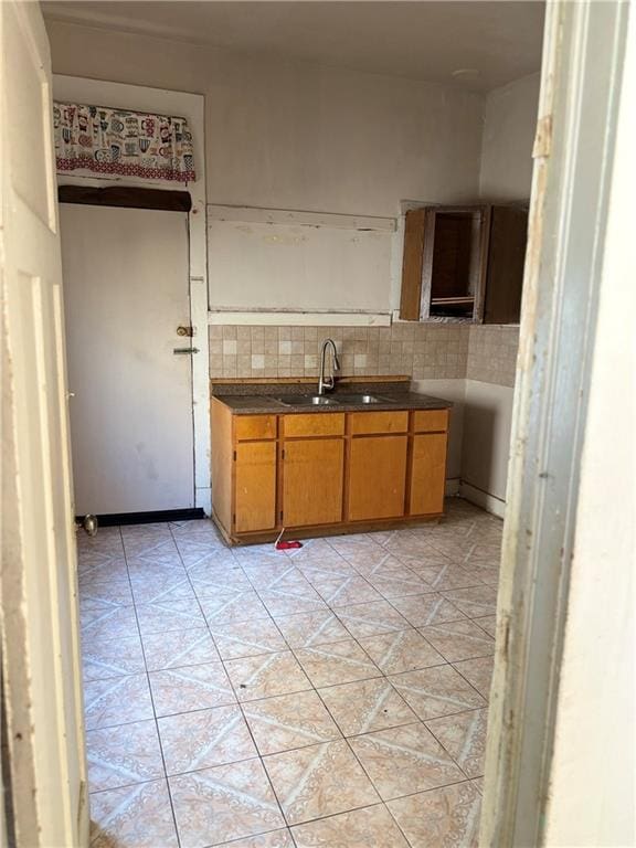 kitchen featuring light tile patterned flooring, tasteful backsplash, and sink