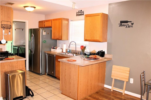 kitchen featuring appliances with stainless steel finishes, sink, and light tile patterned floors