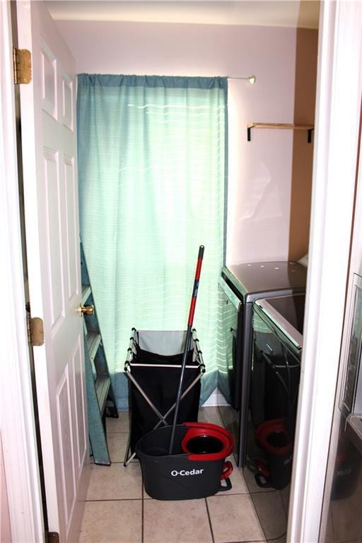 laundry room featuring light tile patterned flooring and washing machine and clothes dryer