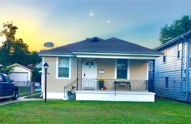 604 Severn Ave, Metairie, LA 70001 - bungalow with covered porch, a garage, an outbuilding, and a lawn