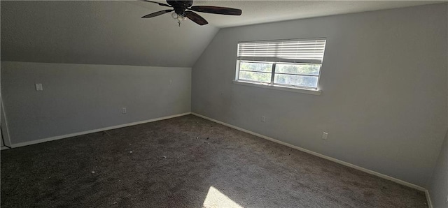 bonus room featuring dark carpet, vaulted ceiling, and ceiling fan