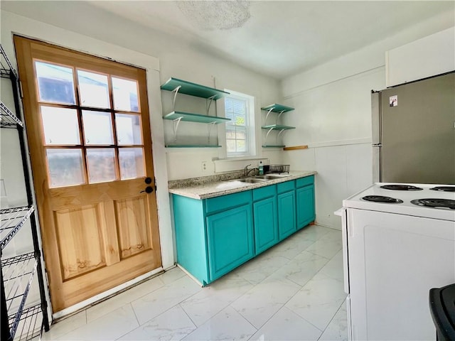 kitchen with blue cabinets, sink, electric range, and stainless steel refrigerator