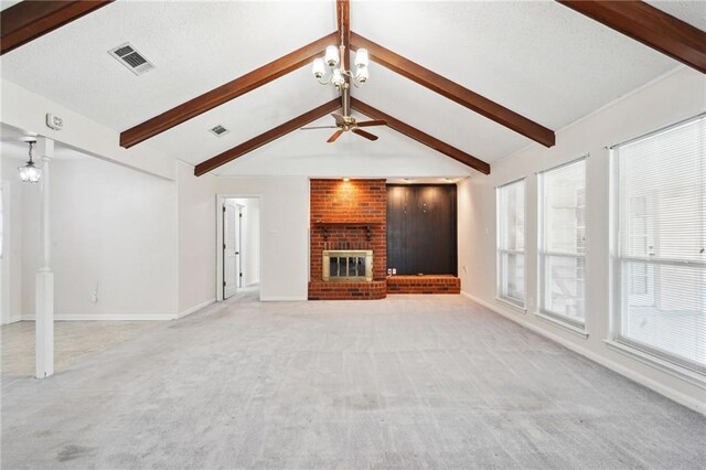 unfurnished living room with ceiling fan with notable chandelier, lofted ceiling with beams, light colored carpet, and a brick fireplace