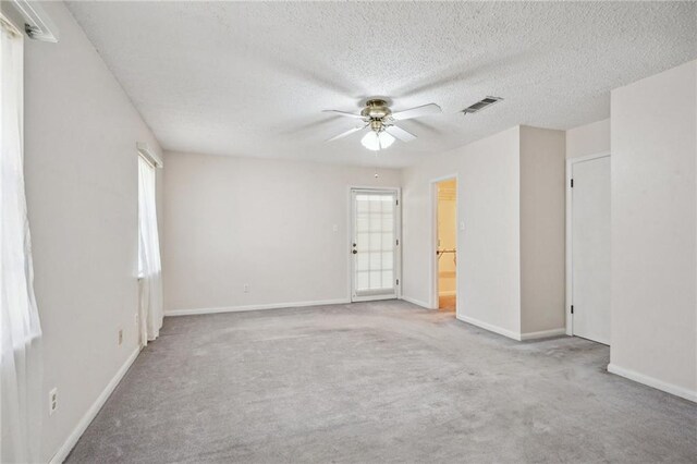 carpeted empty room with a textured ceiling and ceiling fan