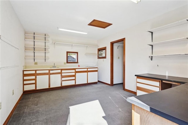 kitchen with dark colored carpet and white cabinetry