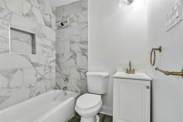 full bathroom with vanity, hardwood / wood-style floors, tiled shower / bath combo, and toilet