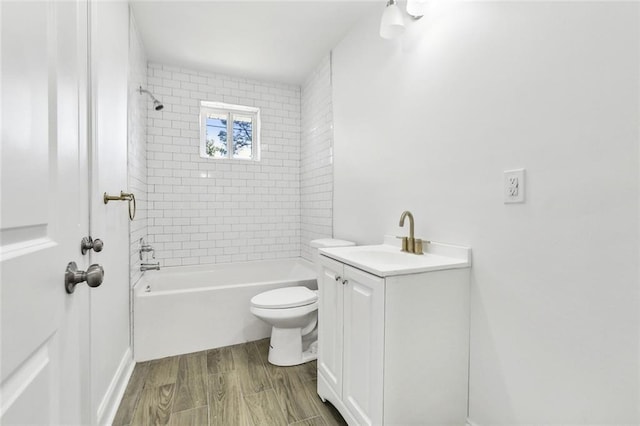 full bathroom with vanity, tiled shower / bath, hardwood / wood-style flooring, and toilet