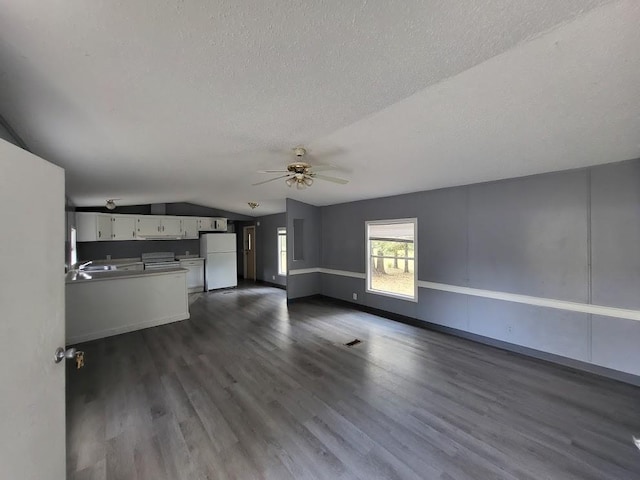 unfurnished living room with ceiling fan, a textured ceiling, vaulted ceiling, and dark hardwood / wood-style flooring