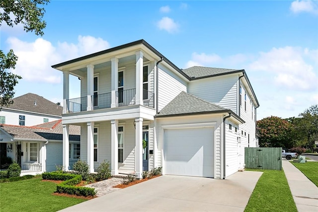 view of front of property featuring a front yard, a balcony, and covered porch