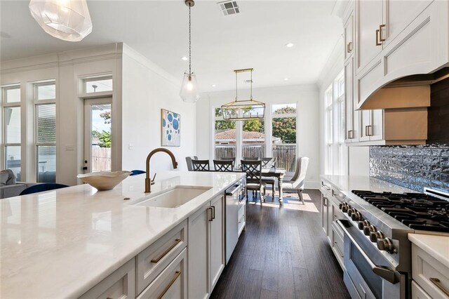 kitchen with dark wood-type flooring, sink, decorative light fixtures, white cabinetry, and appliances with stainless steel finishes