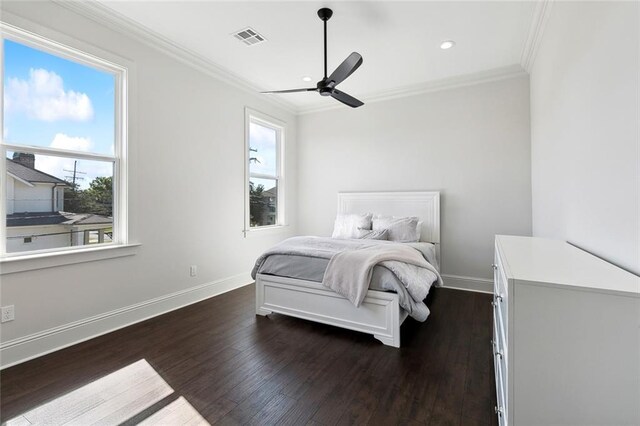 bedroom with dark wood-type flooring, ceiling fan, and crown molding