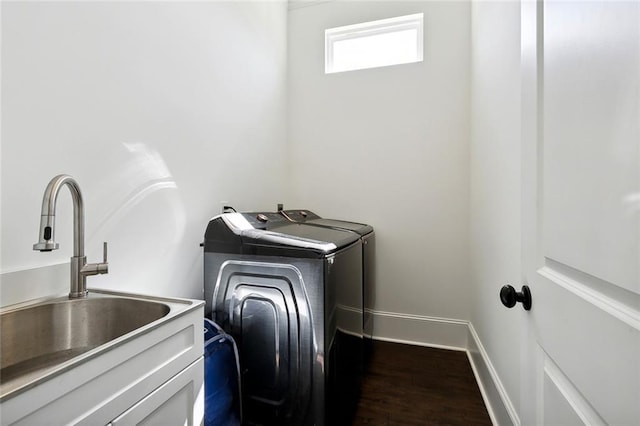 washroom featuring dark hardwood / wood-style flooring, sink, and washing machine and dryer