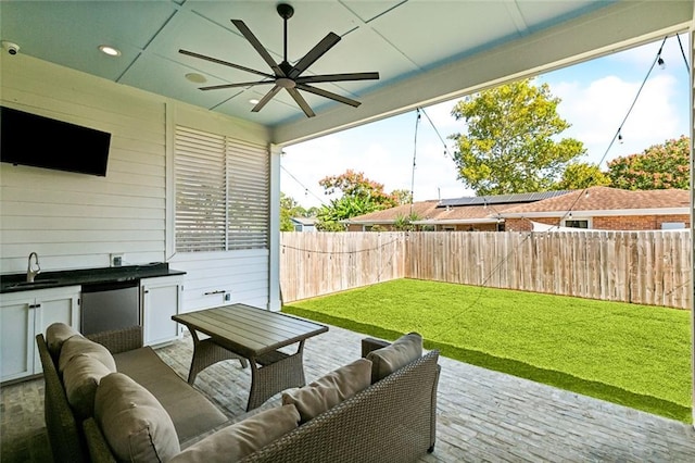 view of patio featuring exterior kitchen, sink, an outdoor living space, and ceiling fan