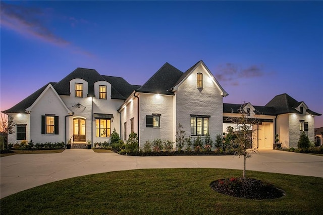 french country style house with a garage and a yard