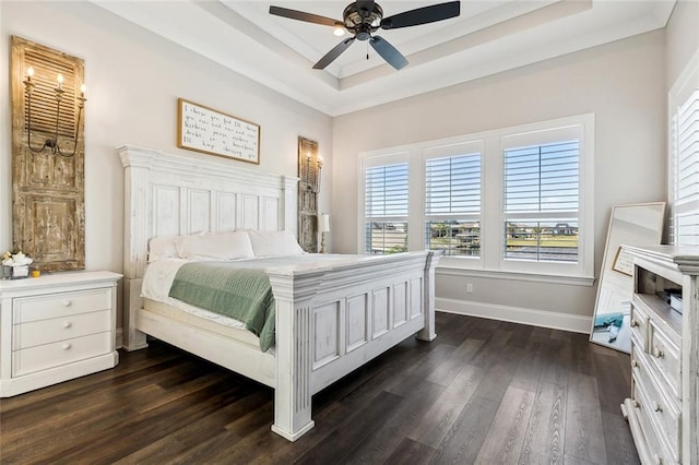 bedroom featuring dark wood-type flooring, ceiling fan, and a raised ceiling