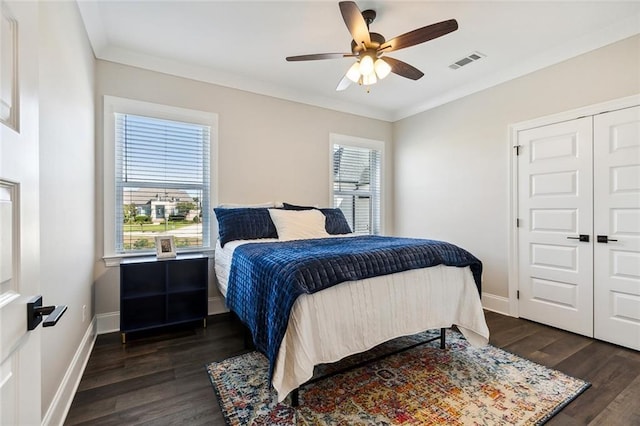 bedroom with multiple windows, ornamental molding, and dark wood-type flooring