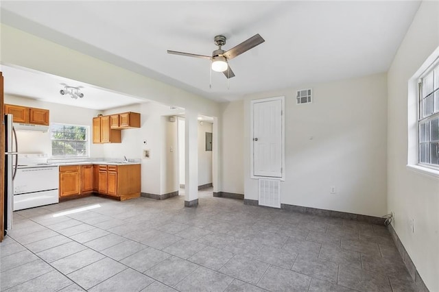 kitchen with ceiling fan, white stove, sink, and light tile patterned floors