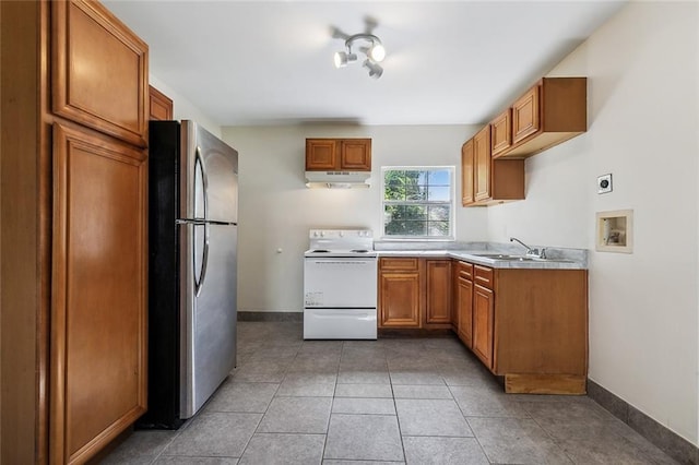 kitchen with tile patterned floors, sink, white stove, and stainless steel refrigerator