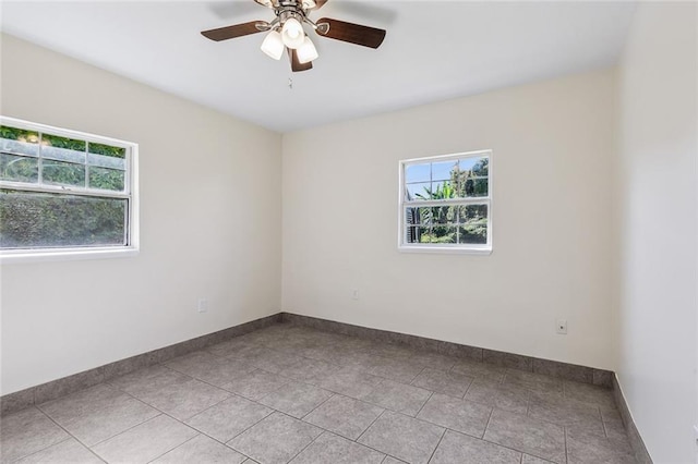 unfurnished room with light tile patterned floors, a healthy amount of sunlight, and ceiling fan