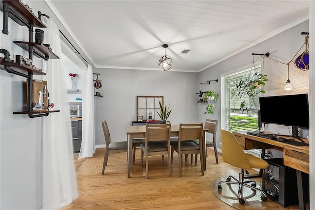 dining area featuring light hardwood / wood-style floors and crown molding