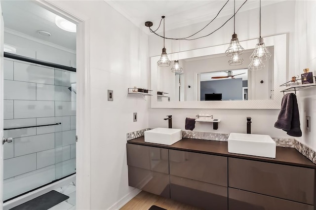 bathroom featuring ceiling fan, wood-type flooring, a shower with shower door, vanity, and crown molding